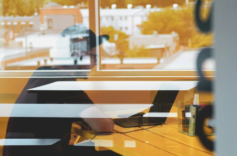 a person sitting at a table with a laptop