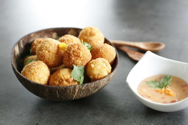 bowl filled with fried food next to spoon and dish