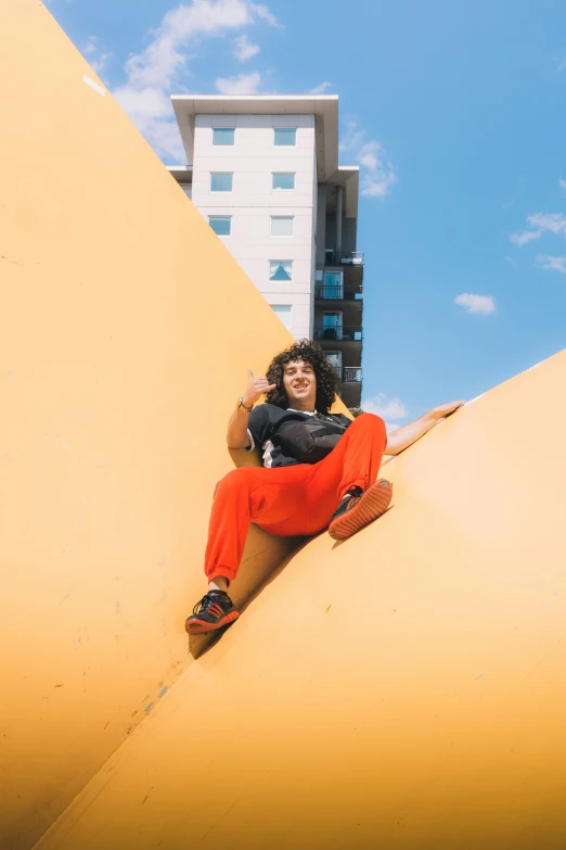 a woman in a black shirt sitting on a yellow structure