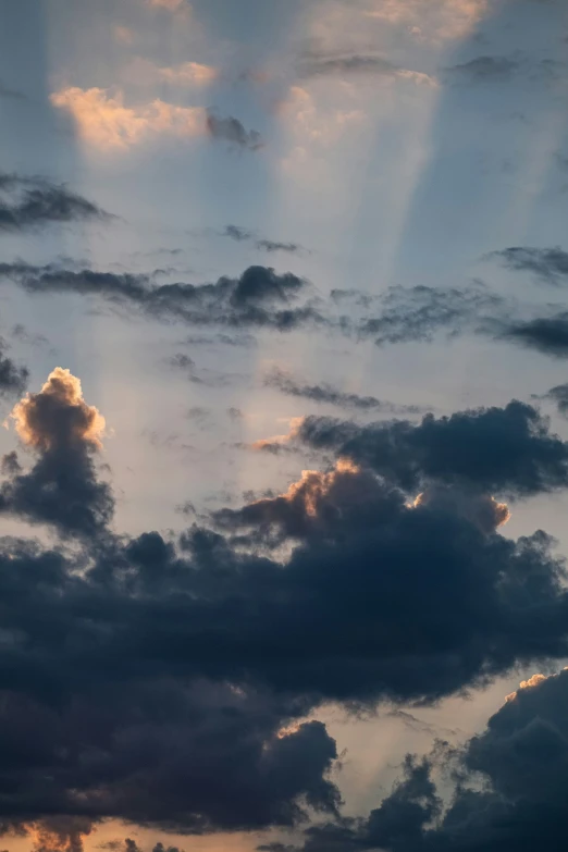 a plane flying under a large, very cloudy sky