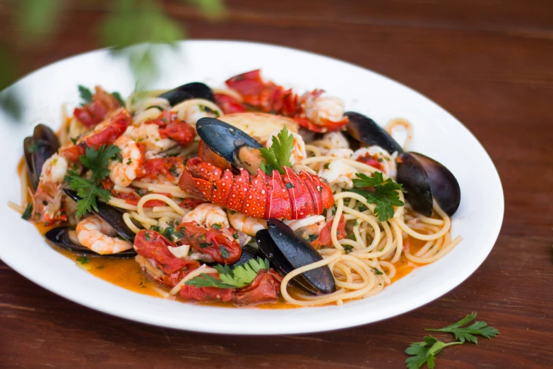 a plate of food containing linguinies, mussels and seafood