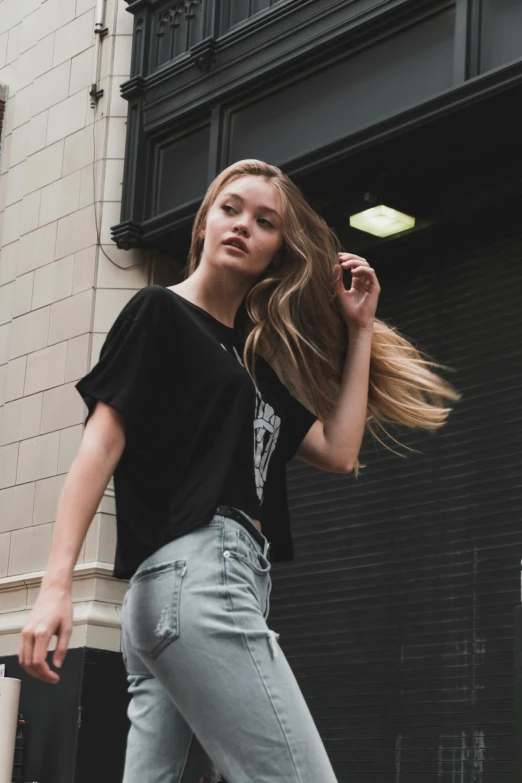 a young lady leaning against a building on the sidewalk