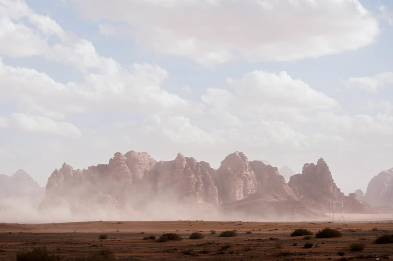 a mountain range with mountains and dust in the foreground