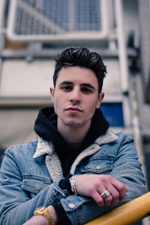 a young man is posing in front of a building