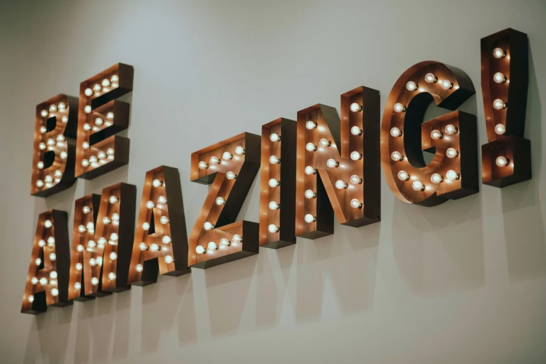 a sign that says be amazing with light bulbs on it