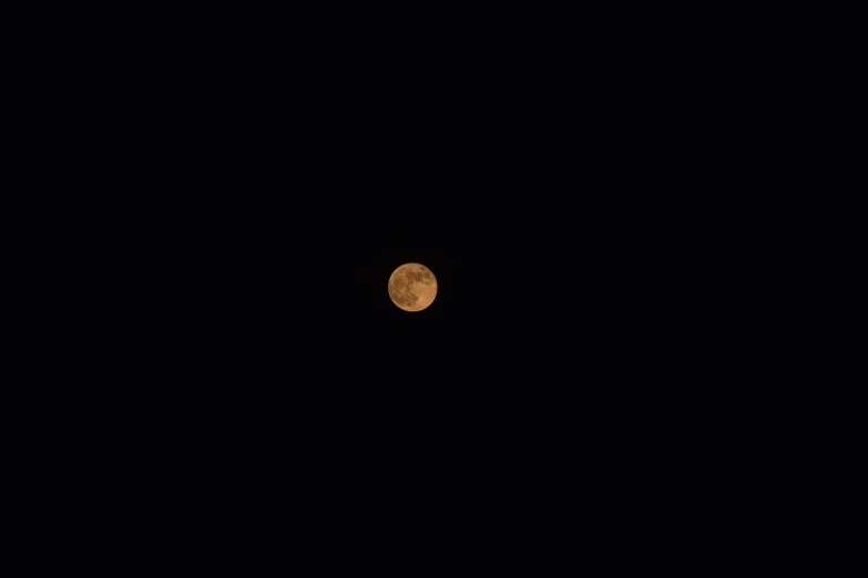 a full moon seen through the dark night sky