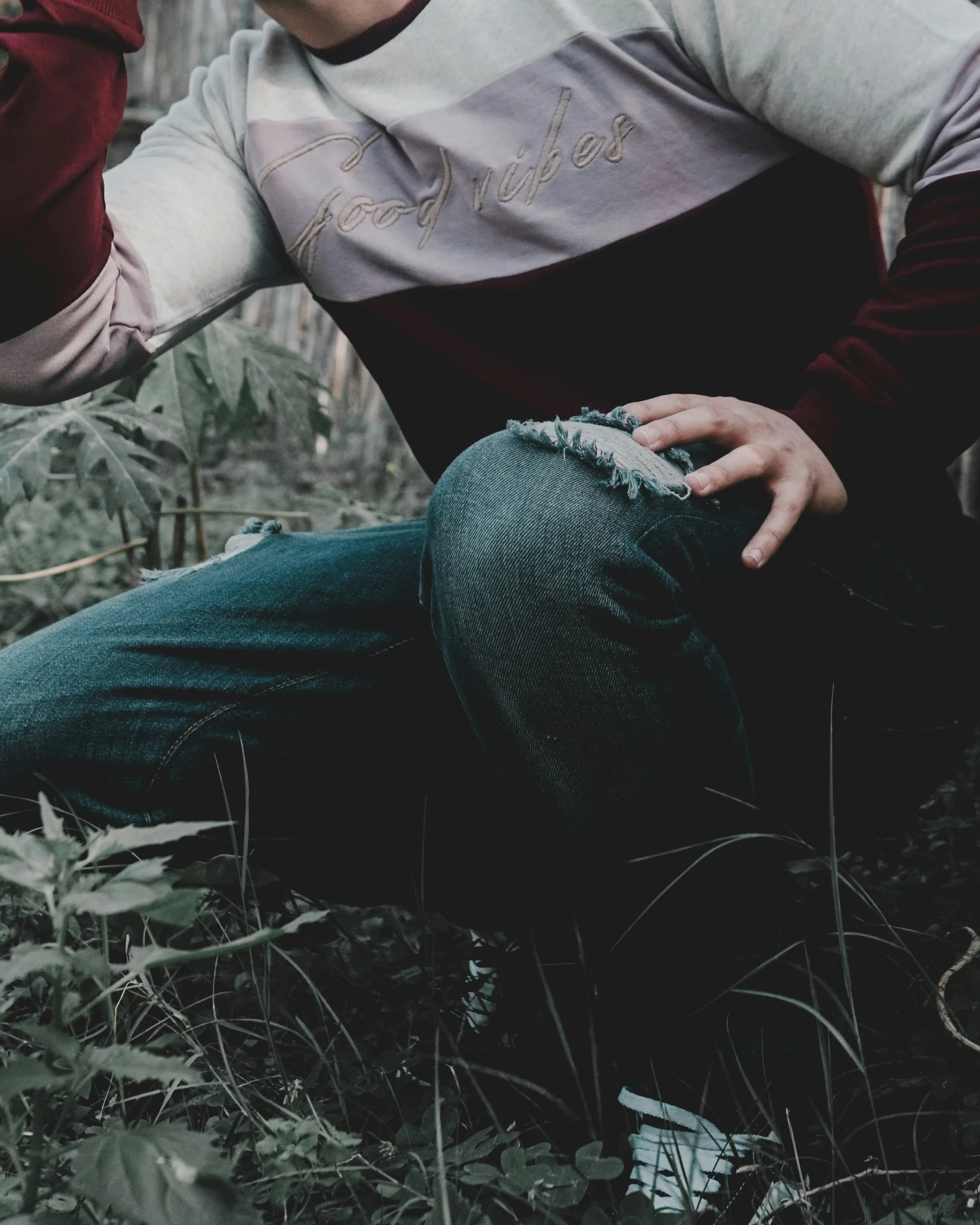 a man wearing a hat sits on the ground