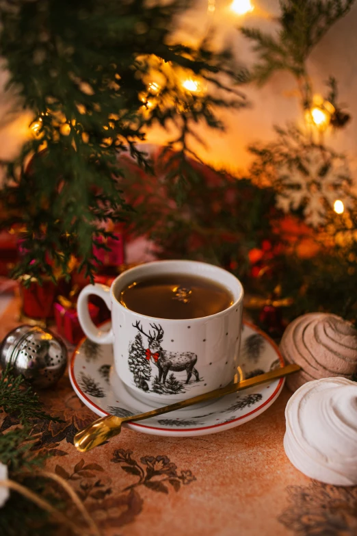 an image of a cup of tea next to a decorated christmas tree