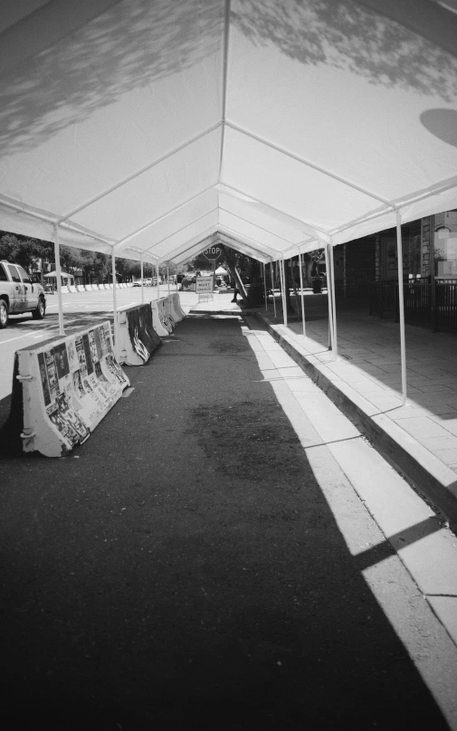 a row of white tents sitting next to each other on top of a sidewalk