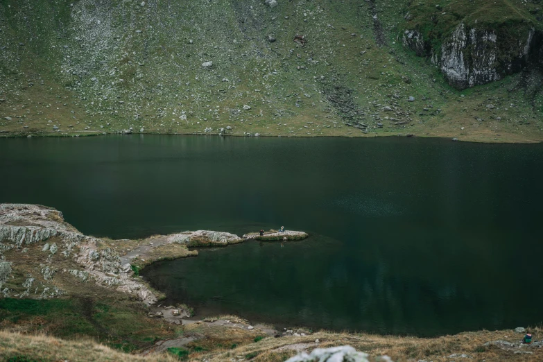 a green mountain lake surrounded by rocks