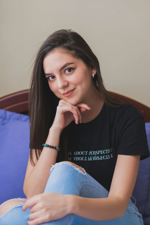 a woman sitting on top of a bed next to a blue blanket