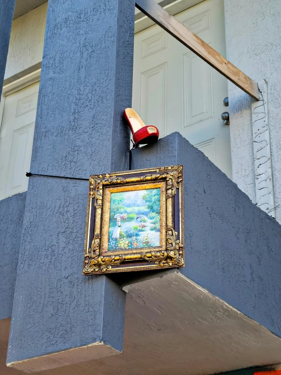 a small portrait hangs from the side of a tall building