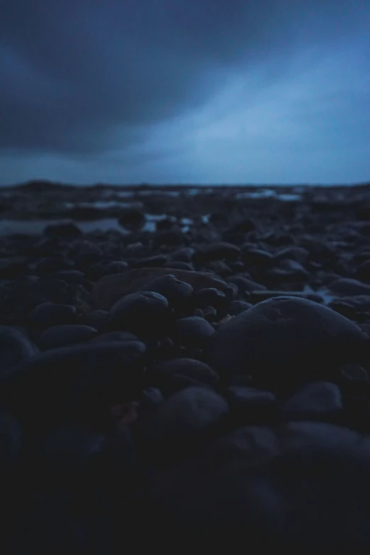 dark ocean water with pebbles in the foreground