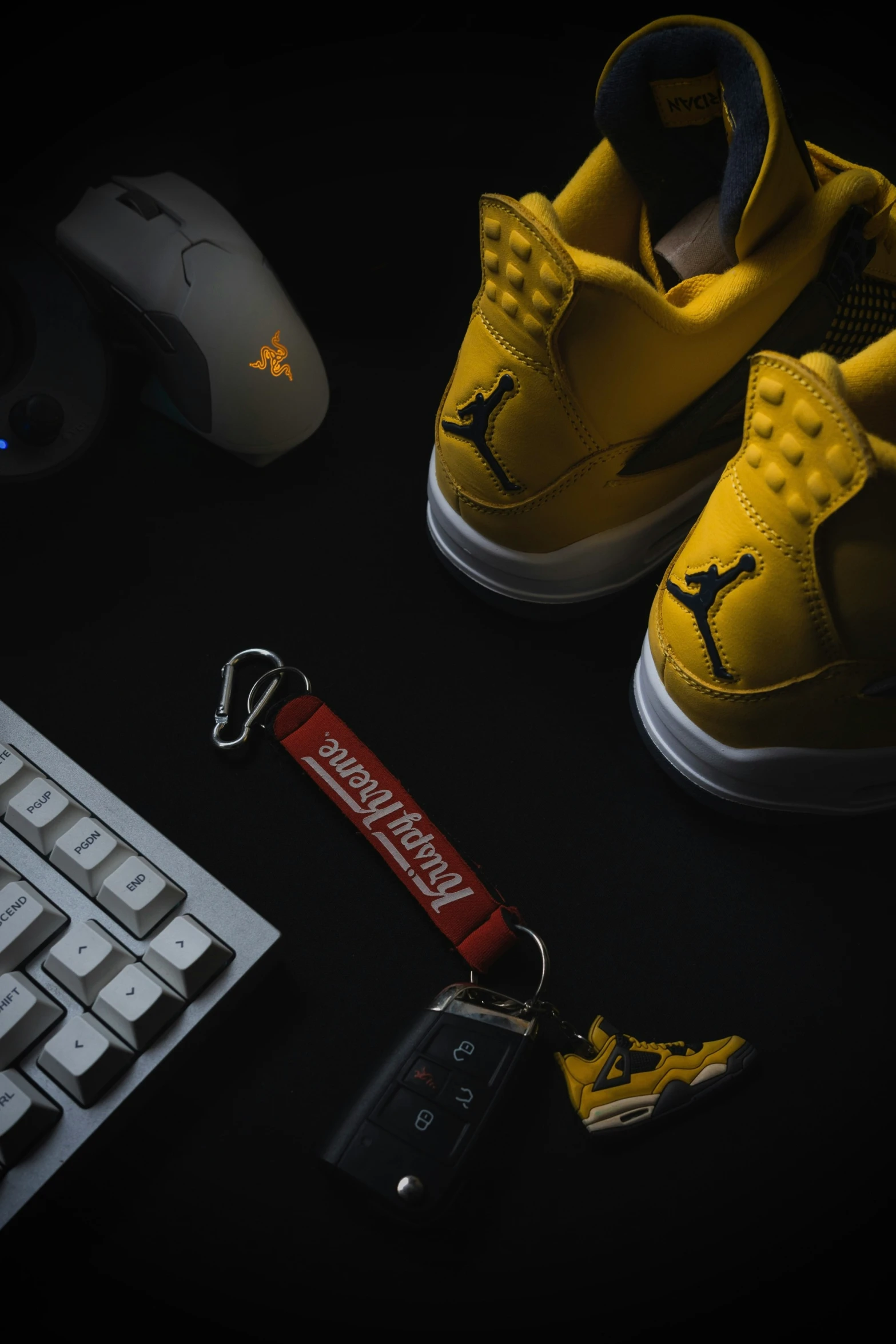 a yellow shoe keychain next to a keyboard and a key fob