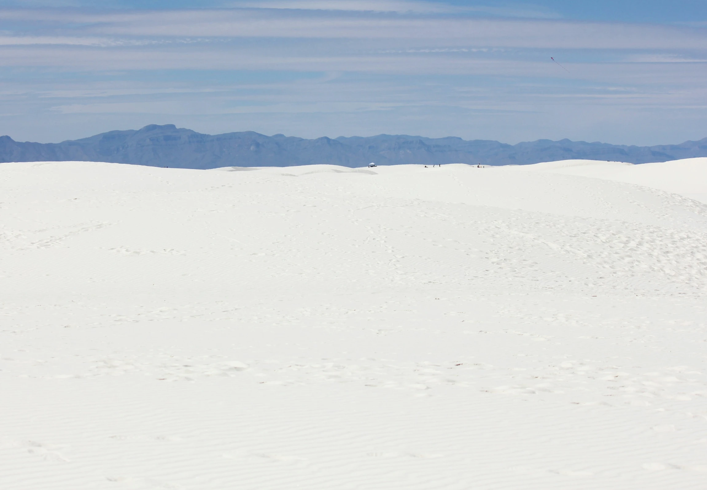 a person is walking in white sand on a cloudy day