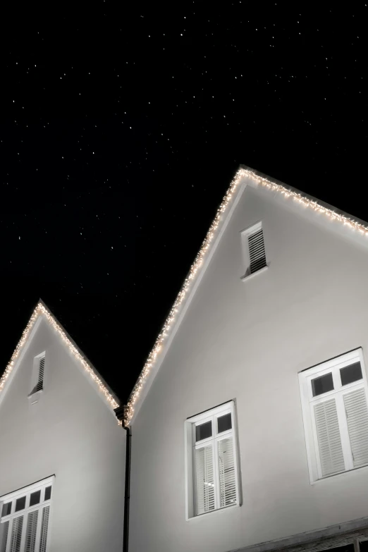 two windows on the side of a building at night