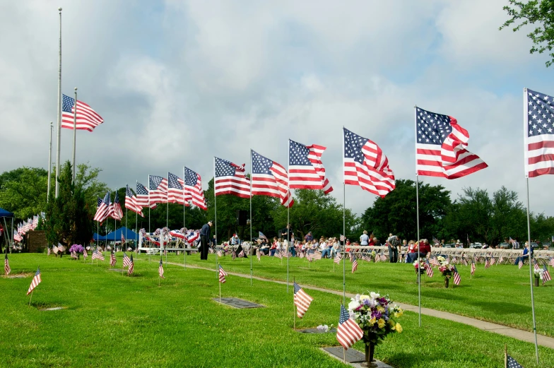 an outdoor memorial is shown with flags flying