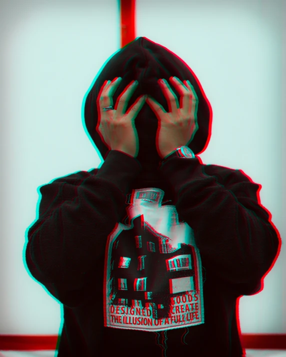 a person wearing a black hoodie is covering his face with both hands