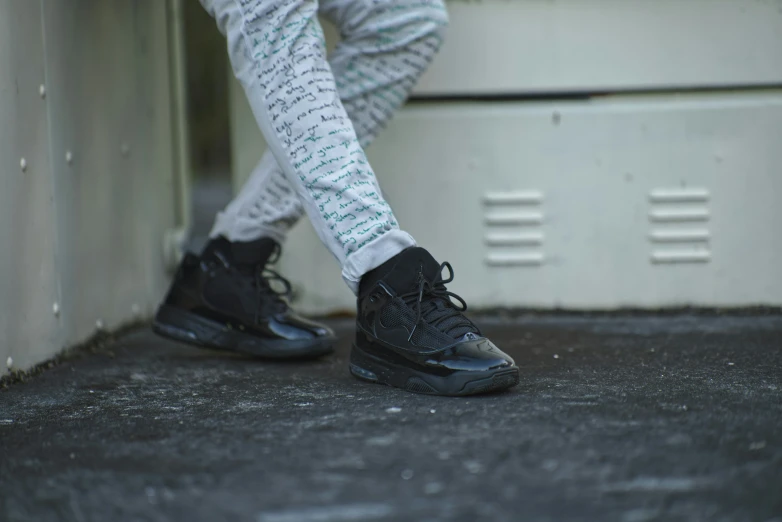 a person wearing black shoes that are sitting on a bench