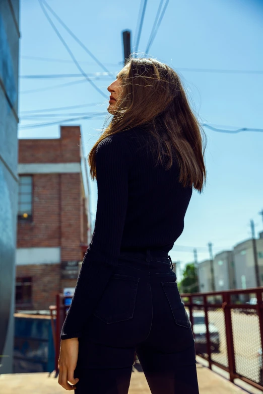 a woman with long brown hair is standing in the street