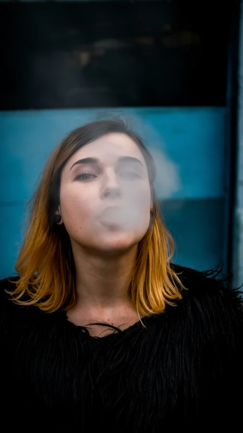 a woman is looking down while smoking a cigarette