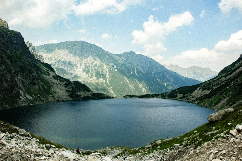 a small lake surrounded by rocks on a mountain