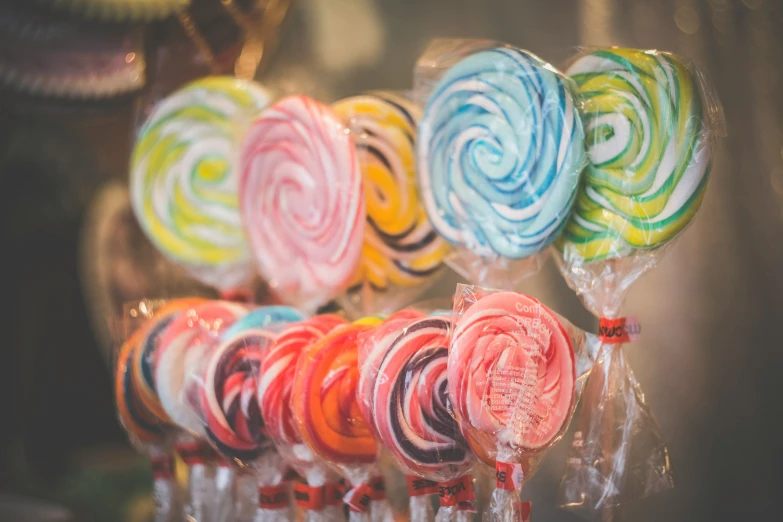 there are many swirl lollipops sitting on display