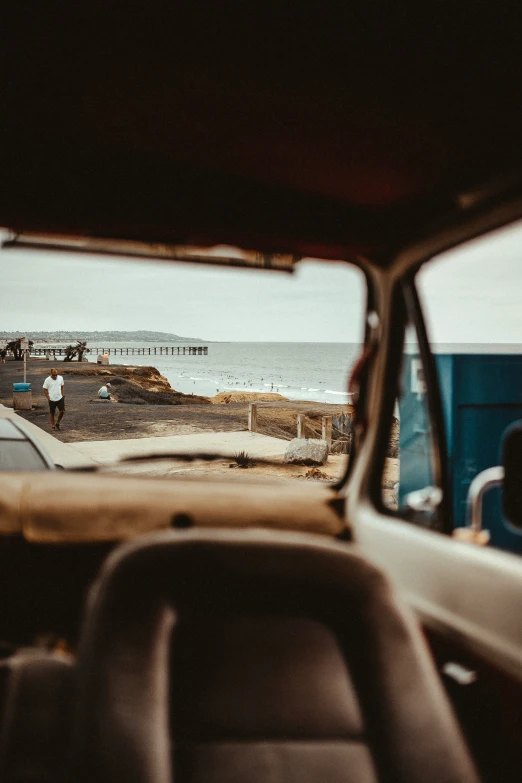 car sitting on side of ocean side with people