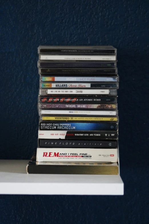 stack of cds sitting on top of a shelf