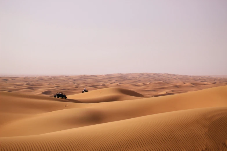 a desert landscape with three cars in the distance