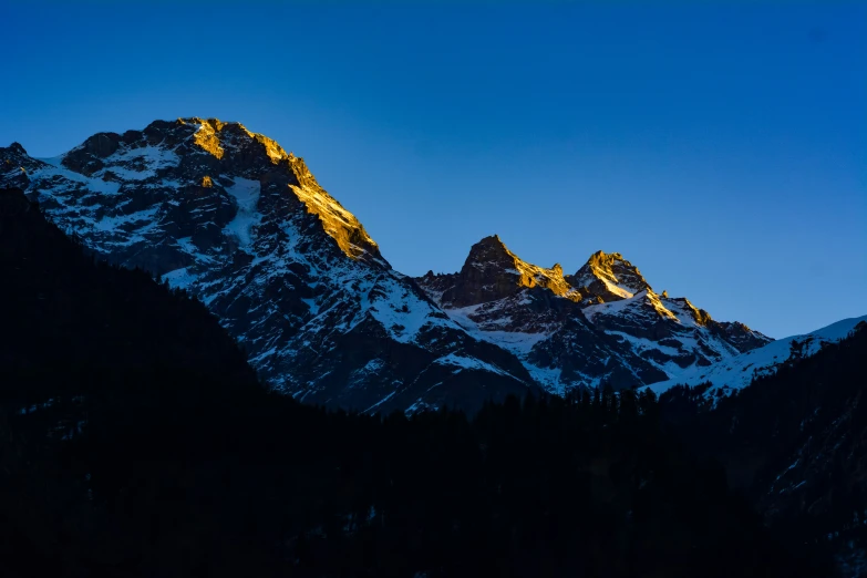two mountain peaks on a dark blue sky