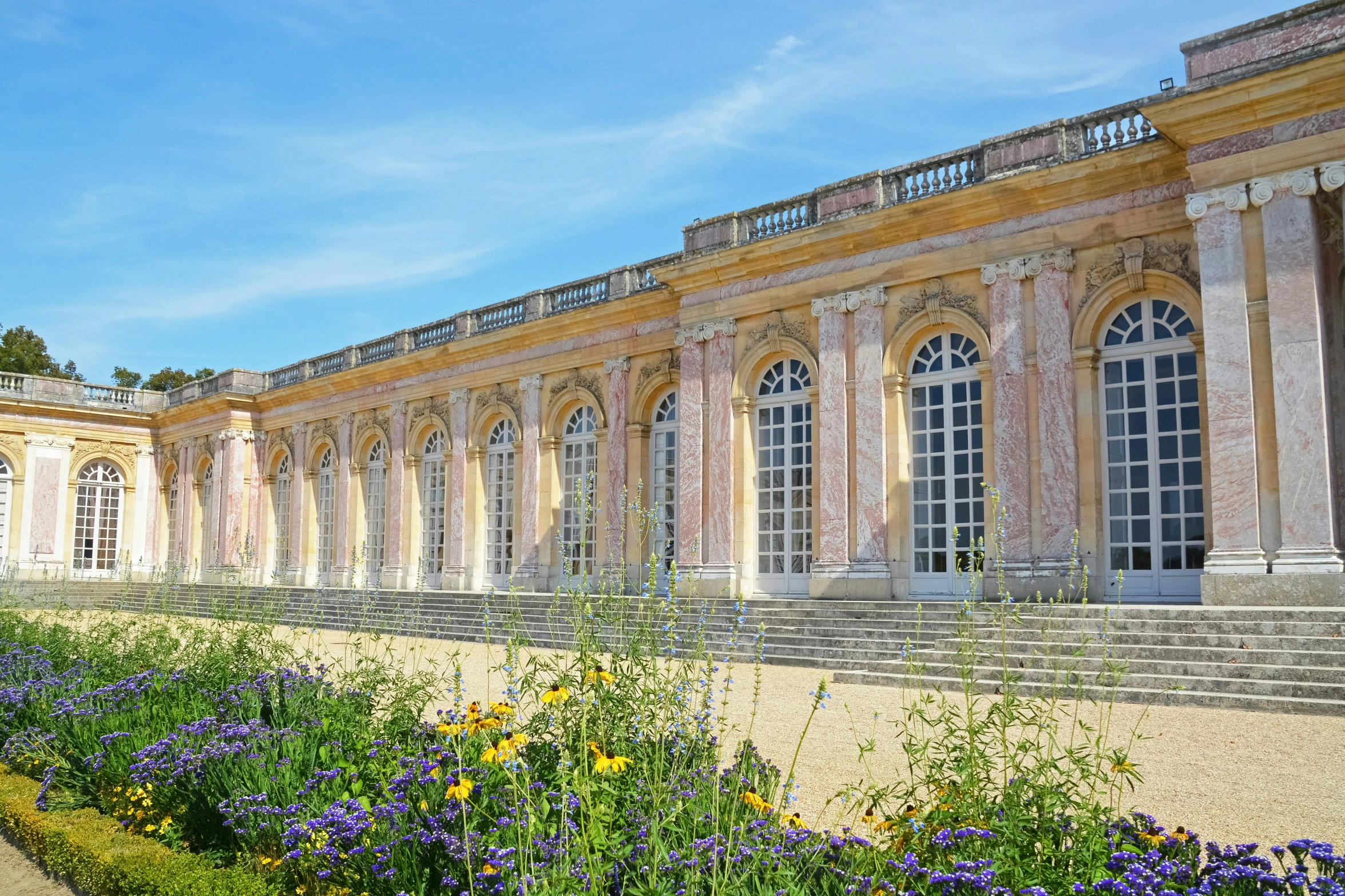 there is a large building with many windows and a lot of flowers