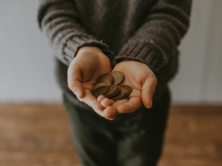 a man is holding coins in his hands