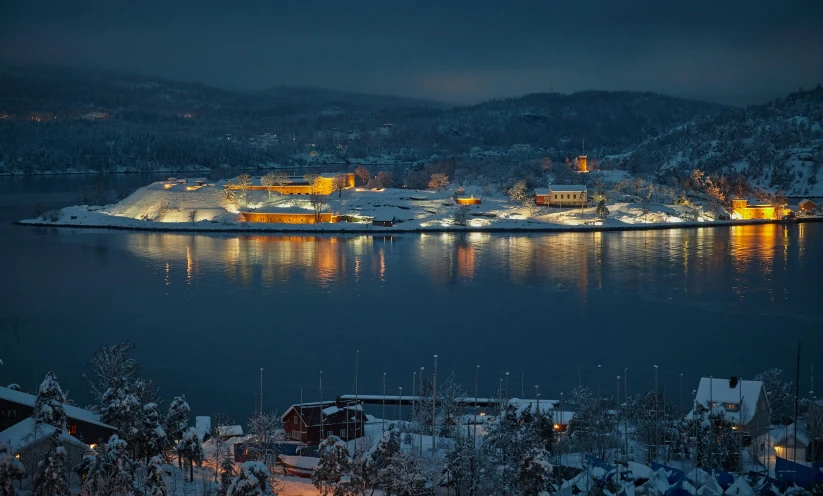 the night view of town next to water with lights on