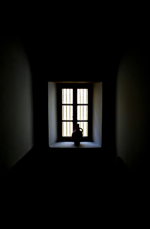 dark room with a small window and one person in the corner