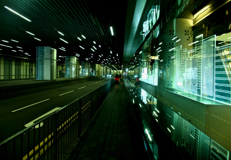 a man with a red shirt walks past an outdoor subway station