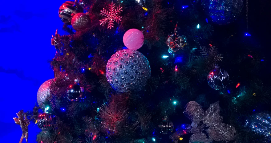 a decorated christmas tree sits brightly lit