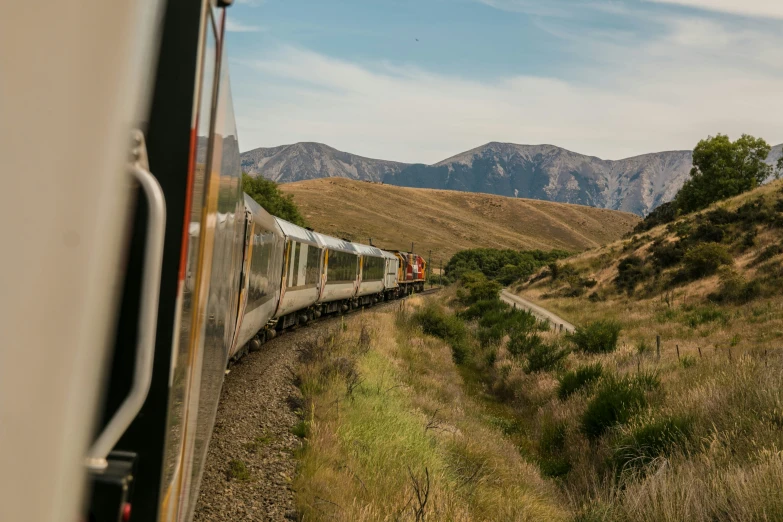 a train traveling through mountains and land on its tracks