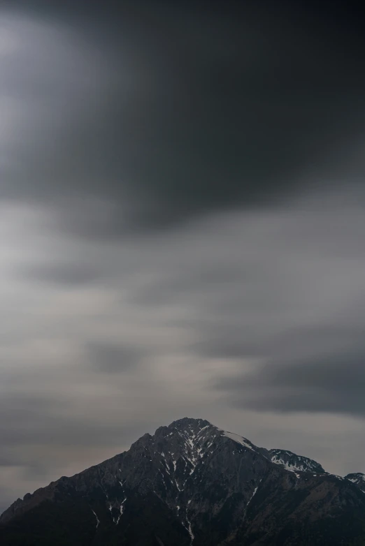 a dark colored sky with mountains and trees behind it