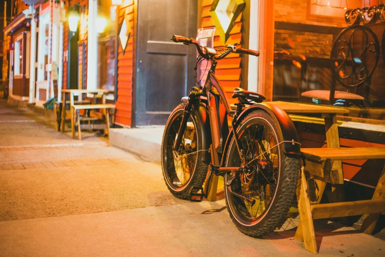 a bike leaning up against a bench outside a restaurant