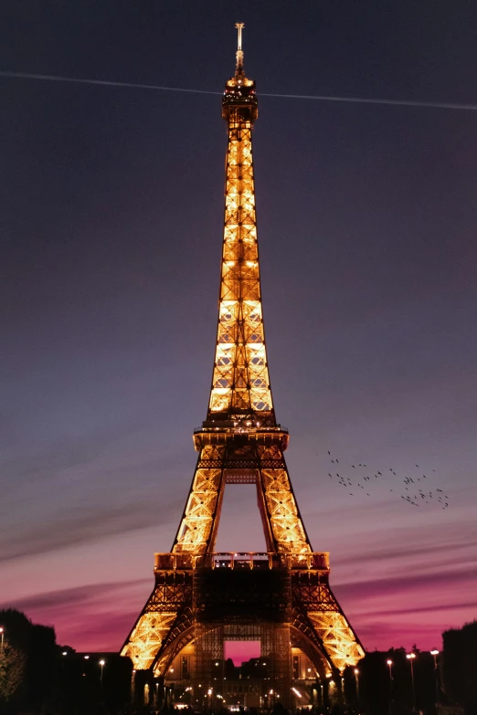 the eiffel tower, in paris lit up at night