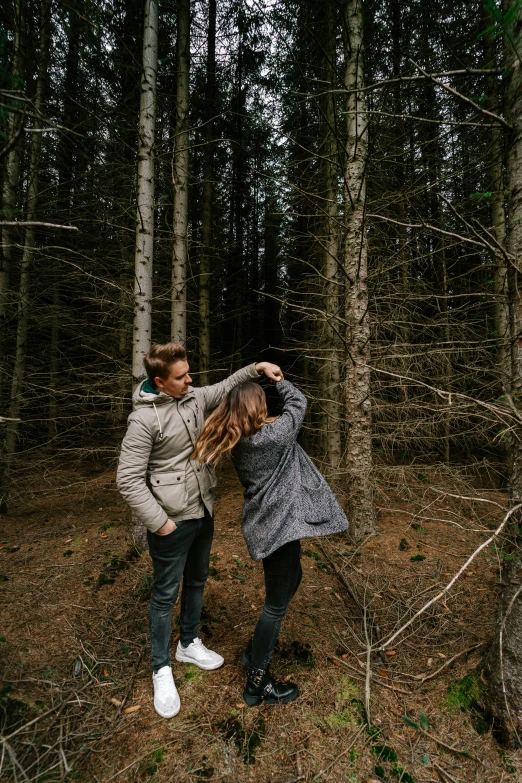 a man and woman in the woods dancing