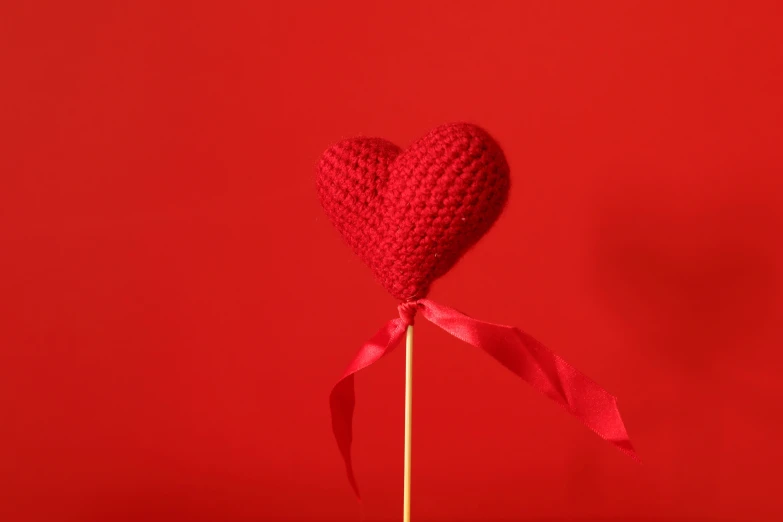 an heart lollipop with a long pink ribbon