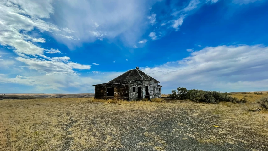 an abandoned, rundown house in a field