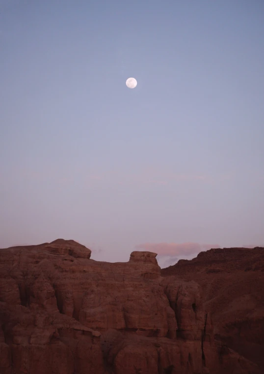 a lone giraffe standing on a rocky cliff