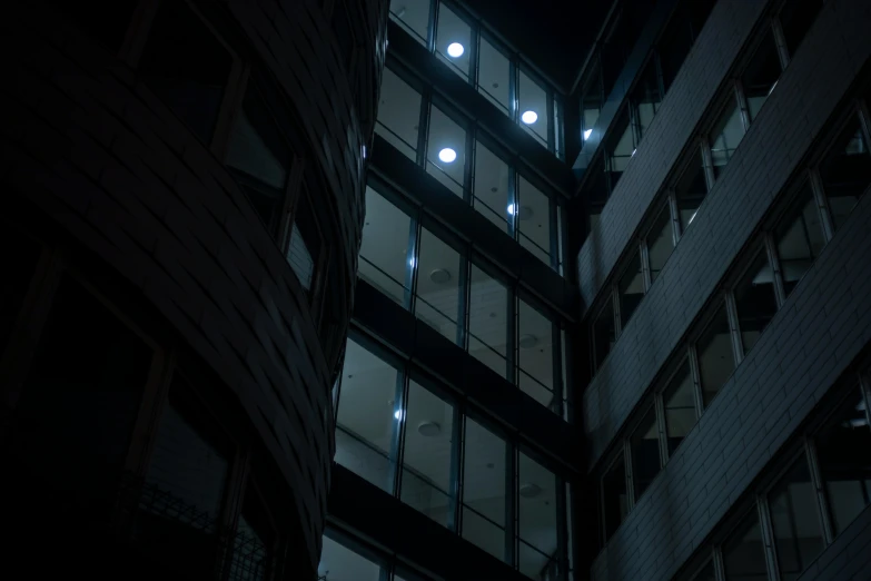 a night s of a lit up window at the back of an apartment building