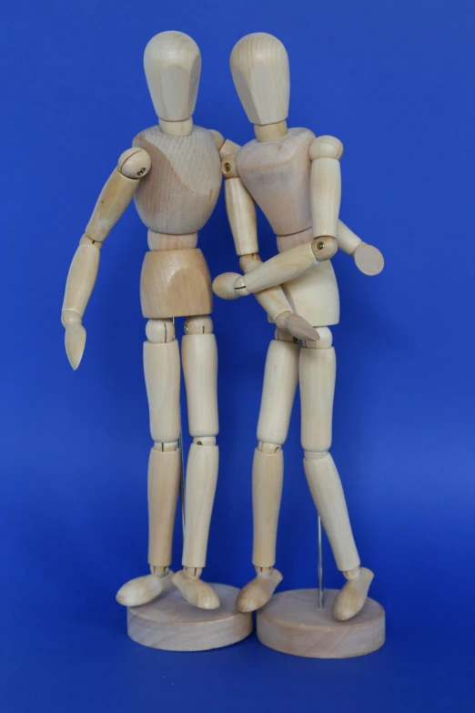 a couple of wood mannequins that are standing next to each other