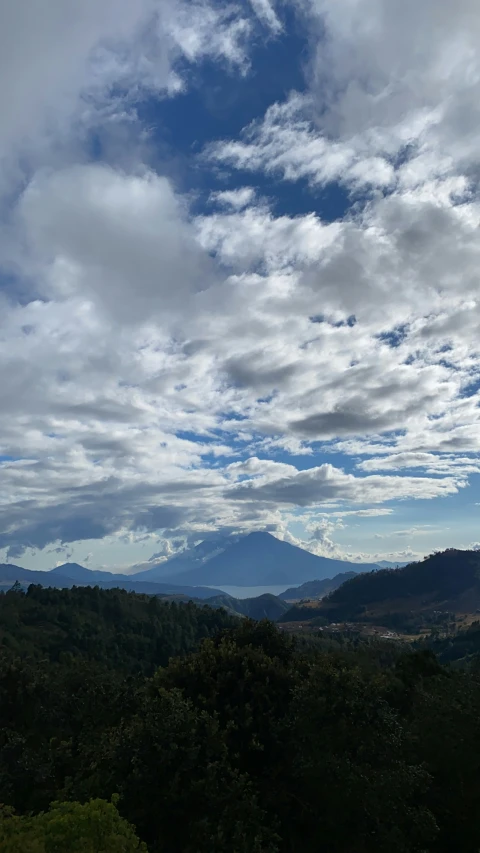 a big hill with some very beautiful trees and clouds