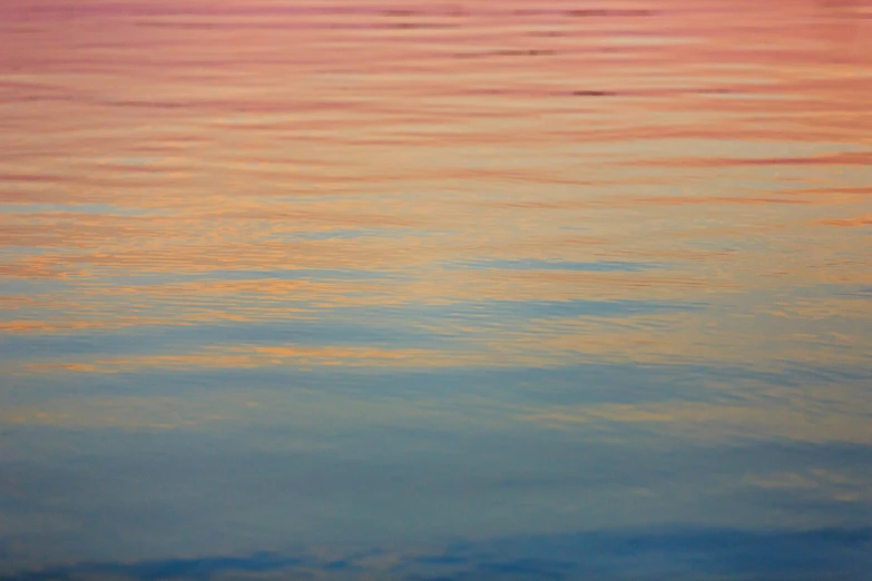 the sky and water are reflecting sunlight and patterns