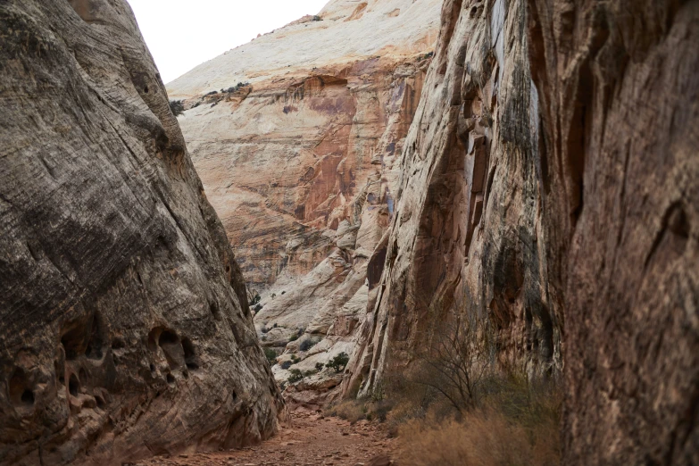 people hiking in a slot between two large, high rock formations